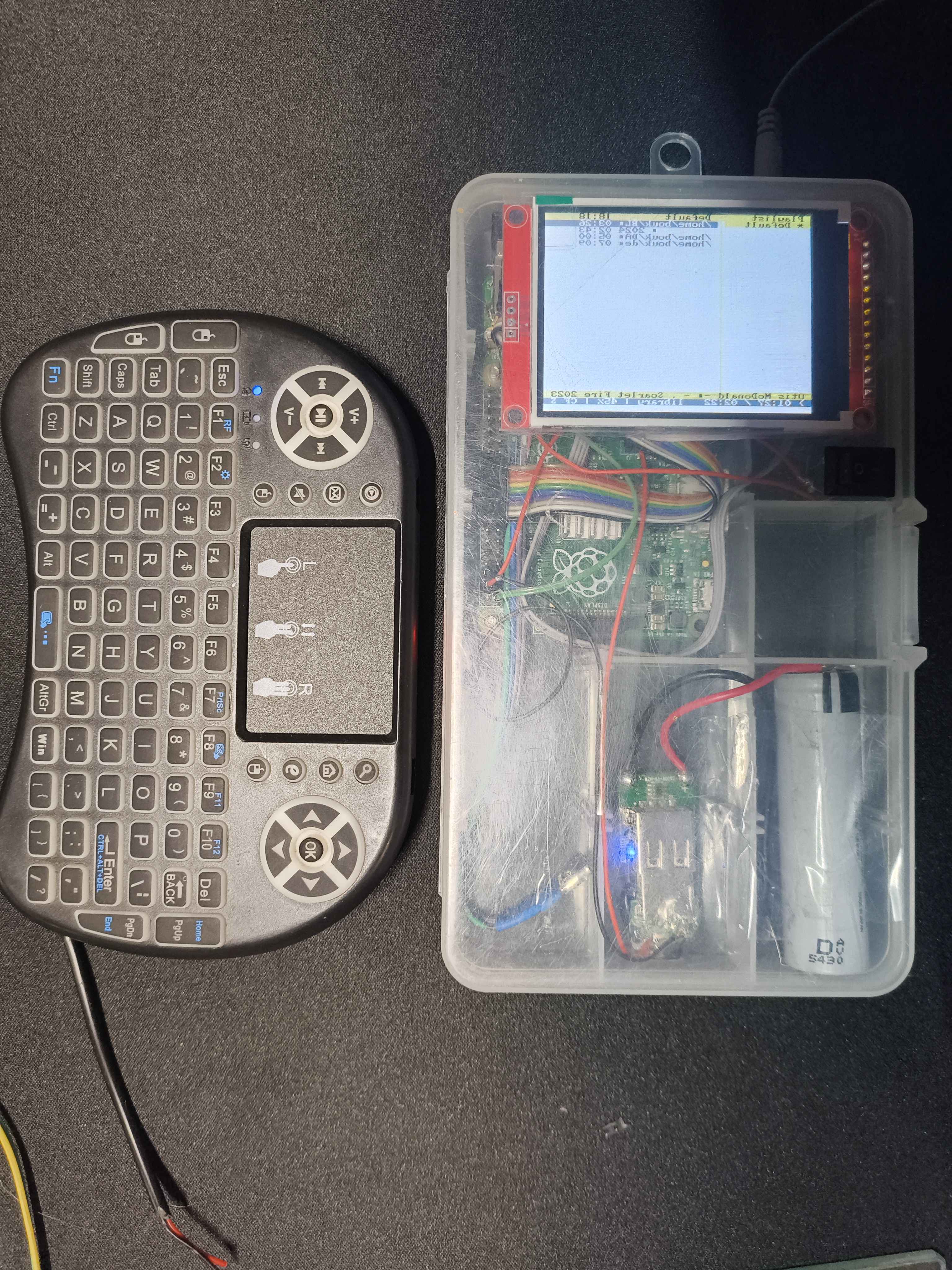 A photo of a prototype music player with a keyboard next to it